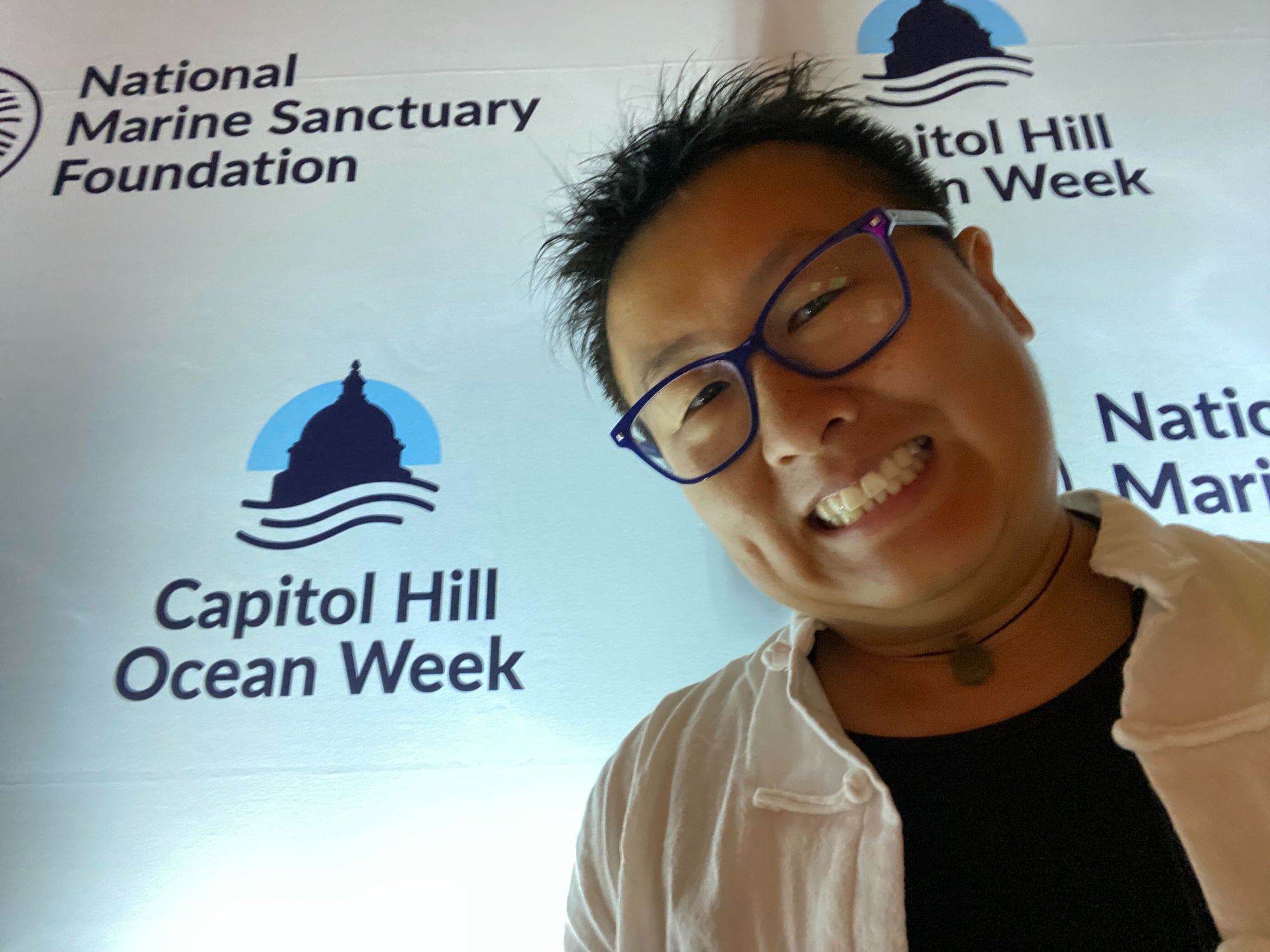 Talia standing in front of a wall that says Capitol Hill Ocean Week