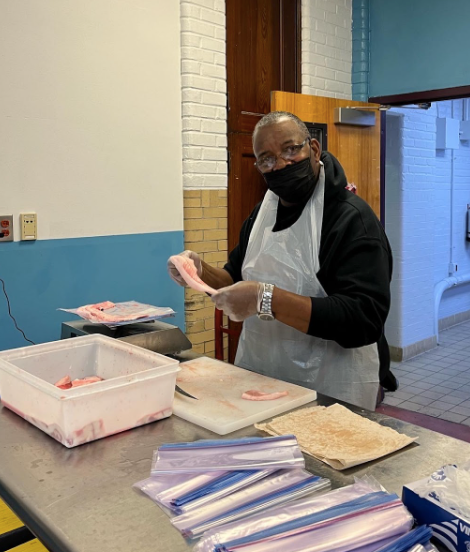 Mr. Rodney holds a fish fillet during a packing session.